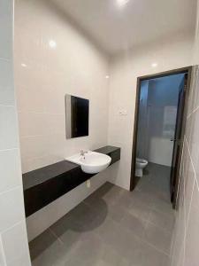 een badkamer met een wastafel en een toilet bij Villa 16pax 3BR with Spa Pool n Pool Table near SPICE ARENA in Bayan Lepas