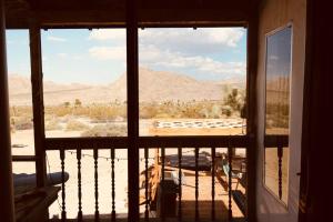 a view of the desert from a balcony of a house at Joshua Tree’s Highland Hideaway Compound in Joshua Tree