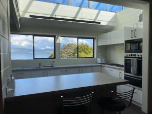 a kitchen with two windows and a large kitchen island at The Willows in Rotorua