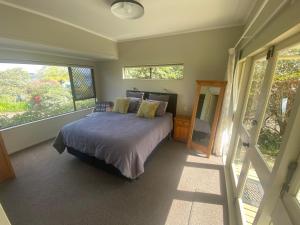 a bedroom with a bed and a large window at The Willows in Rotorua
