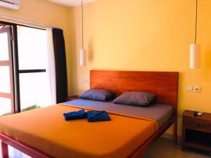 ein Schlafzimmer mit einem Bett mit zwei blauen Handtüchern darauf in der Unterkunft KELAN-TEL BALI in Jimbaran