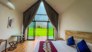 a bedroom with a large bed with a large window at Vangvieng Angsavanh Resort in Vang Vieng