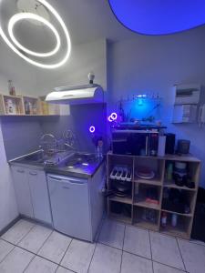 een keuken met paarse verlichting en een aanrecht met een wastafel bij Jacuzzi au cœur de Bordeaux in Bordeaux