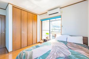 una camera con letto e finestra di LONG VACATION a Shirahama