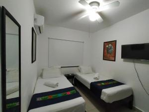 ein Zimmer mit zwei Betten und einem Flachbildfernseher in der Unterkunft Casa MEXH Lunamar - Ideal para familias, vacaciones o homeoffice in Playa del Carmen + 33 Fotos