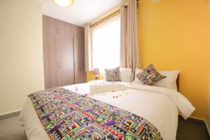 um quarto com uma cama com um cobertor colorido em Lantern Serviced Apartments em Nairobi