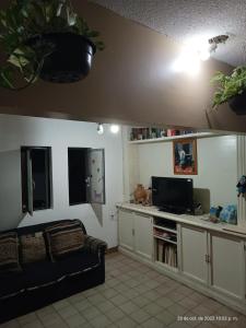Casa de Claudia y Hugo في مدينة أواكساكا: غرفة معيشة مع أريكة وتلفزيون بشاشة مسطحة