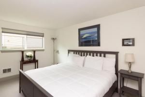 a bedroom with a large white bed with two tables at RIVERWALK SEASIDE- Walk to beach, One level home, pet friendly in Seaside