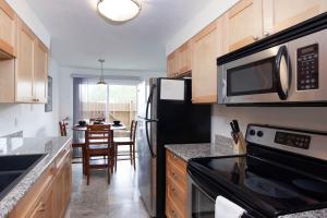 a kitchen with a black refrigerator and a microwave at RIVERWALK SEASIDE- Walk to beach, One level home, pet friendly in Seaside