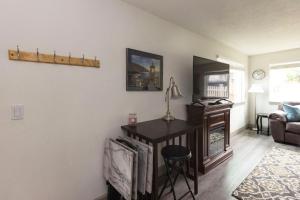 a living room with a table and a television at RIVERWALK SEASIDE- Walk to beach, One level home, pet friendly in Seaside