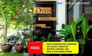 a sign in front of a building with plants at Oasis Hotel & Apartment in Da Nang