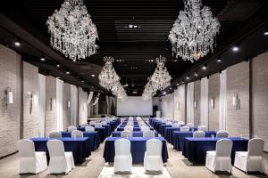 una sala con tavoli blu, sedie bianche e lampadari a braccio di Hotel Bernoui Seoul a Seul