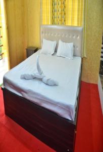 a bed with two white towels on top of it at Jaldapara Riverhine by StayApart in Uttar Simlabari