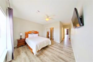 a bedroom with a bed and a flat screen tv at Lions Meadow in Dickinson