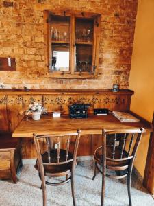 een houten tafel met 2 stoelen en een raam bij Vintage-Design Ferienwohnung Viktoria in Bad Klosterlausnitz