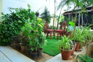 a garden with chairs and potted plants at Mojo M Villa -Airport Boutique Hotel in Jaipur