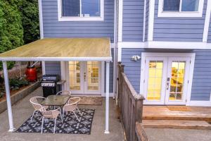 una casa blu con un tavolo e sedie su un portico di NEW: Bright, Peaceful Retreat in Iconic Seattle Neighborhood a Seattle