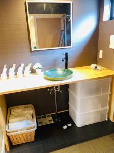 y baño con lavabo y espejo. en ゲストハウス至の宿 Shibainu-Themed Guesthouse en Kyoto