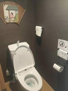 a bathroom with a white toilet in a stall at ゲストハウス至の宿 Shibainu-Themed Guesthouse in Kyoto