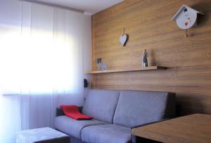 ein Wohnzimmer mit einem Sofa und einer Holzwand in der Unterkunft ALPINE HOUSE - Dolomiti Affitti in Cavalese