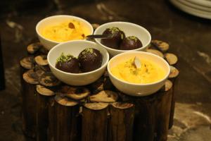 a plate of food with bowls of food and mushrooms at Hotel Kamran Palace in Ahmedabad