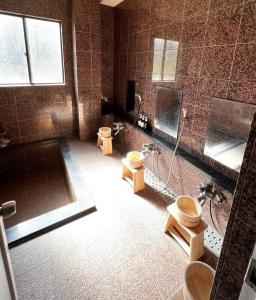 a bathroom with two toilets and a shower at Lodge Seizan in Nozawa Onsen