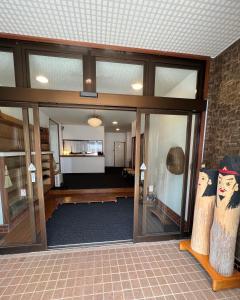 a lobby with glass doors and a living room at Lodge Seizan in Nozawa Onsen