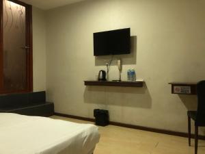 a bedroom with a bed and a flat screen tv at Super OYO 90668 Joy Inn in Miri