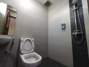 ein kleines Bad mit einem WC und einer Dusche in der Unterkunft Super OYO 90668 Joy Inn in Miri