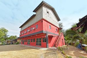 un grand bâtiment rouge avec un toit gris dans l'établissement Capital O 90664 Rabi Hotel, à Kota Bharu