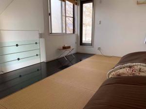 1 dormitorio con vestidor y 1 cama con alfombra en Away From Noise,View Fuji Mt In The Designer House en Yamanakako