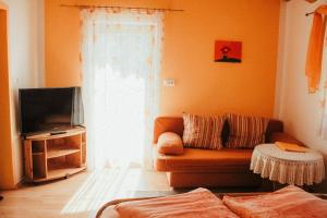 a living room with a couch and a television at Haus Rupitsch in Winklern