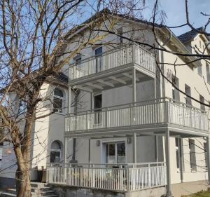 a large white house with a balcony on it at Ferienwohnung Mathilda mit Meeresrauschen in Lubmin