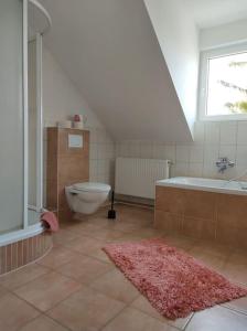 a bathroom with a toilet and a tub and a sink at Ferienwohnung Mathilda mit Meeresrauschen in Lubmin +12 photos