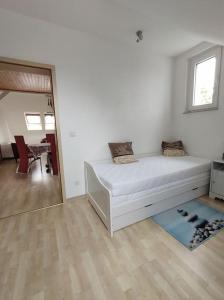 Habitación blanca con cama y espejo en Ferienwohnung Mathilda mit Meeresrauschen, en Lubmin