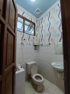 a bathroom with a toilet and a sink at Puri Merbabu Asri 