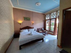 a bedroom with a bed and a large window at Puri Merbabu Asri 