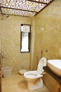 a bathroom with a toilet and a sink at Hotel Saideep Villas, Shirdi in Shirdi