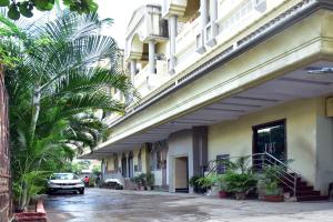 a car parked next to a building with palm trees at Hotel Saideep Villas, Shirdi in Shirdi