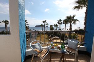 a balcony with a table and chairs and the ocean at Hodo House in Seogwipo