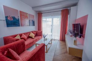 a living room with a red couch and a table at The Breeze Luxury Apartment in Nuwara Eliya