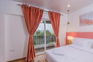 ein Schlafzimmer mit einem Bett und einem großen Fenster in der Unterkunft The Breeze Luxury Apartment in Nuwara Eliya