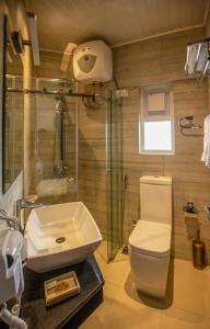 a bathroom with a toilet and a sink and a shower at The Breeze Luxury Apartment in Nuwara Eliya