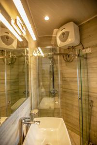 ein Bad mit einer Glasdusche und einem Waschbecken in der Unterkunft The Breeze Luxury Apartment in Nuwara Eliya