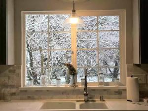 een aanrecht met een raam met een met sneeuw bedekte boom bij Cozy private home, 1 acre orchards near Apple Hill in Placerville