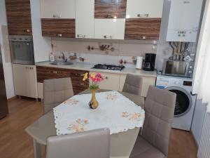 a kitchen with a table with a vase of flowers on it at Cosy apartment I in Târgu-Mureş