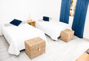 a room with two beds and two wicker baskets at Habitación Agua - Villa Valle Campo 
