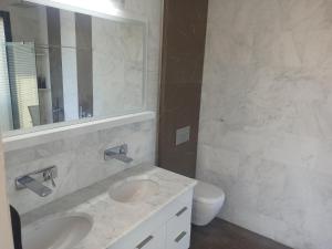 クシャダスにあるVilla Eliteのバスルーム(洗面台2台、鏡、トイレ付)