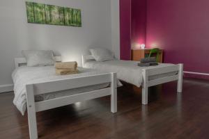 um quarto com duas camas e uma mesa e uma parede roxa em L'Orgelétaine : Grande Maison au milieu des Lacs du Jura em Orgelet
