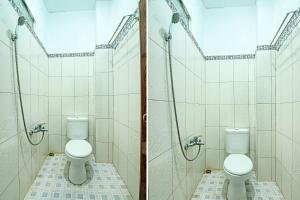 - deux toilettes dans une salle de bains avec deux stalles dans l'établissement OYO 91852 Prima Guesthouse Syariah, à Padang